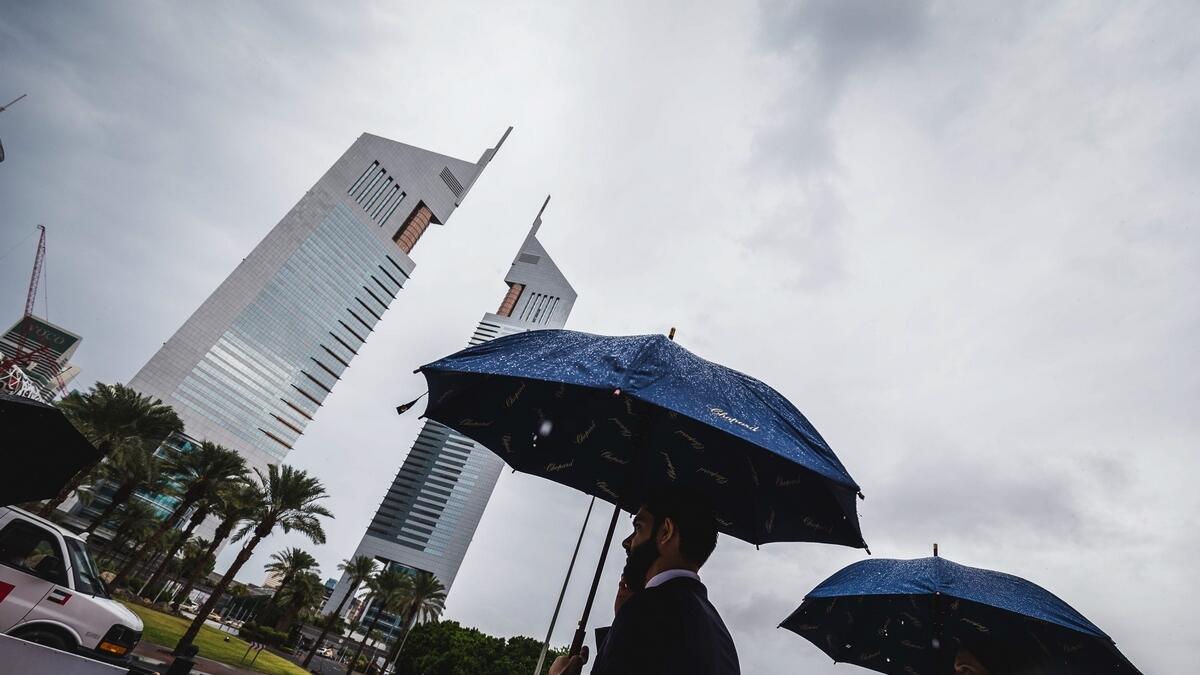 Pedestrians in DIFC use an umbrella following heavy downpour across the United Arab Emirates on November 20, 2019. -Photo by Neeraj Murali/Khaleej Times