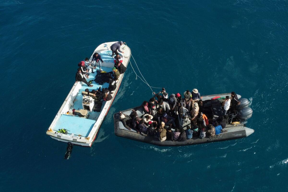 An aerial picture shows boats transporting migrants of different nationalities entering a port in the Garabulli area following their rescue at sea by the Libyan Coast Guard, on Tuesday. — AFP
