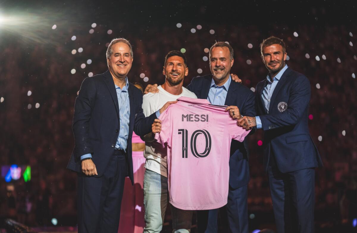 Lionel Messi is presented with his new jersey by Inter Miami co-owner David Beckham (right). — Inter Miami Twitter