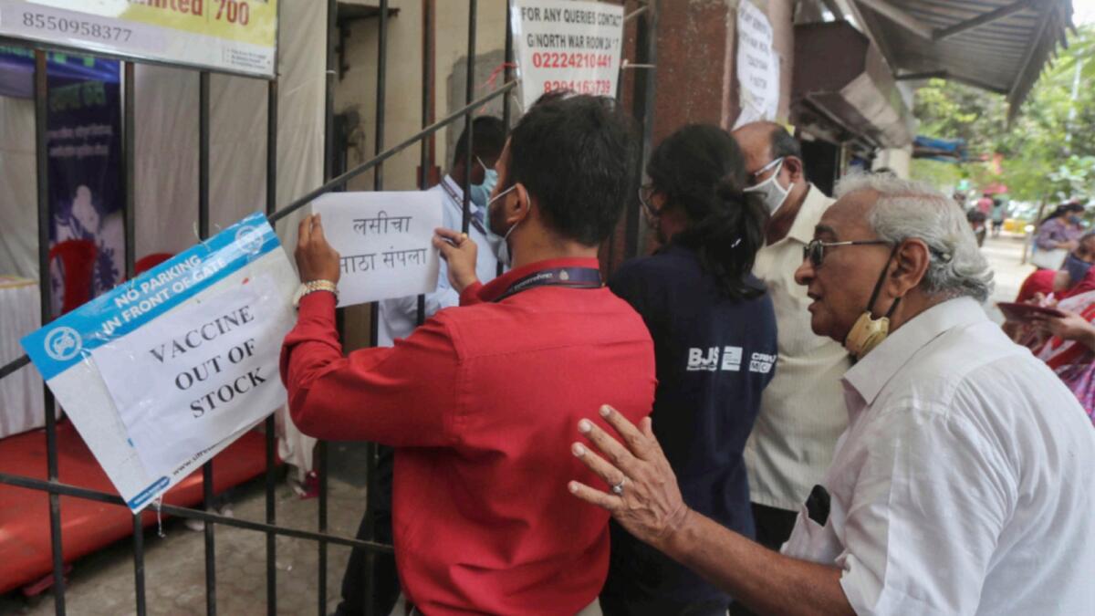 A health worker displays a notice about the shortage of coronavirus vaccine supply outside a vaccination centre in Mumbai. — AP