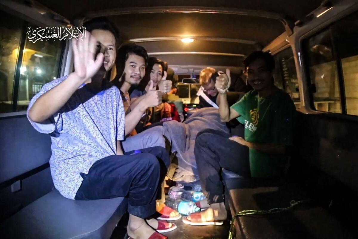 Thai hostages waving aboard a Red Cross vehicle, in the Gaza Strip early on November 26, 2023.