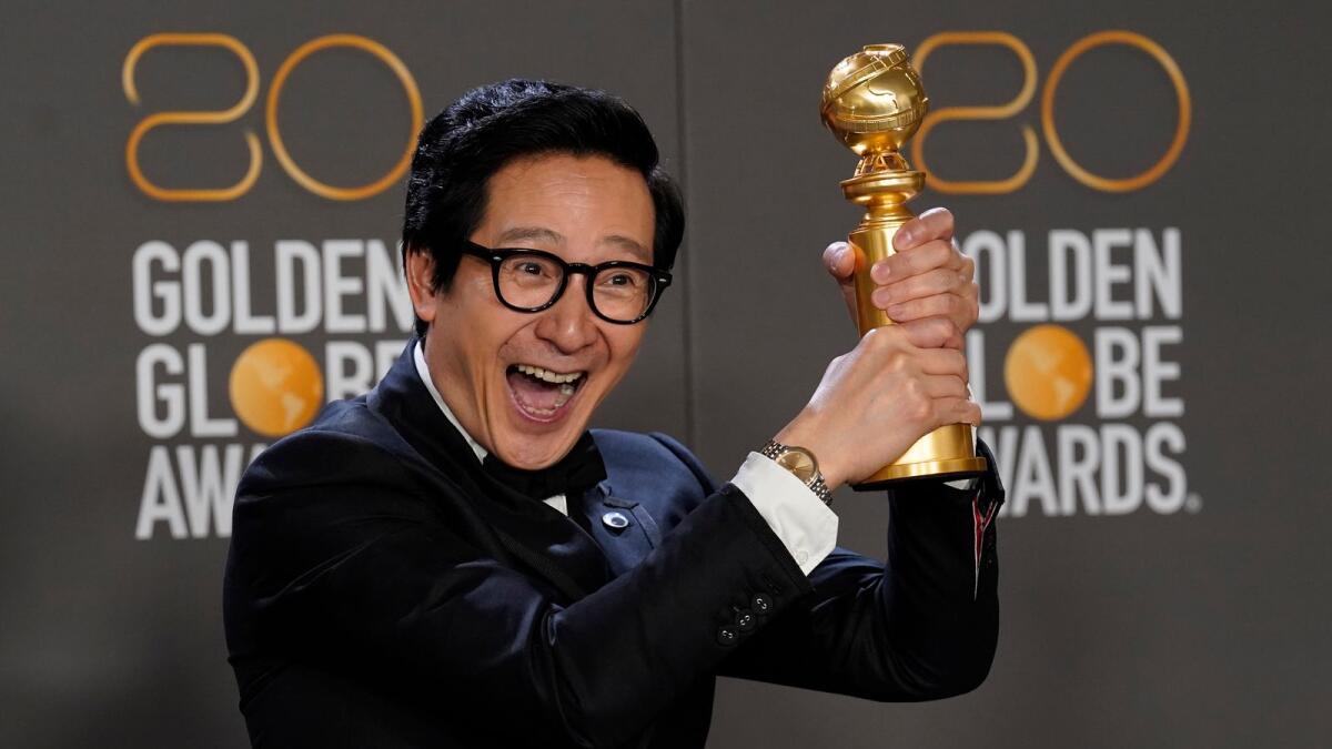 Ke Huy Quan poses in the press room with the award for best performance by an actor in a supporting role in any motion picture for 'Everything Everywhere All at Once'