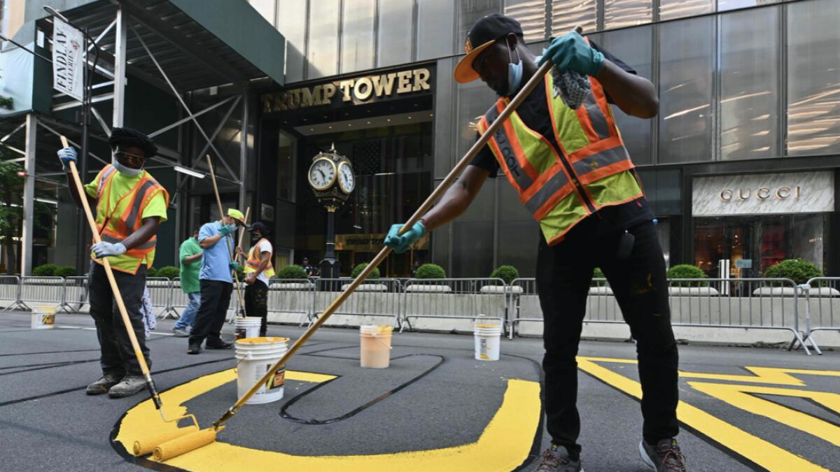 Activists paint a new Black Lives Matter mural outside of Trump Tower on Fifth Avenue in New York City. USA. Photo: AFP
