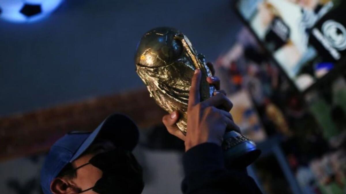A fan holds up a replica of the World Cup trophy in the church. (Reuters)
