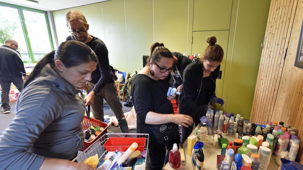 Helpers handling donations for refugees at a hall where the migrants wait for transport to asylum seekers facilities in Dortmund, Germany, Sunday, Sept. 6, 2015. (AP photo)