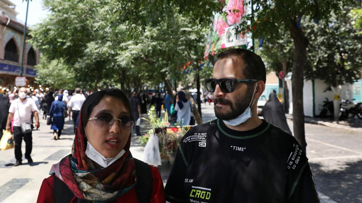 Fatemeh Rekabi, an accountant stands next to her friend Omid Alimardani at Tehran’s Grand Bazaar.