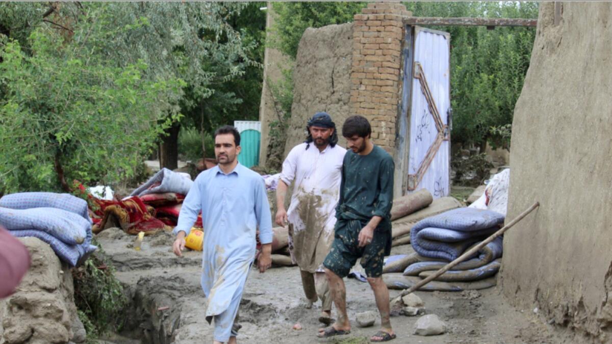 People check their damaged homes after heavy flooding in the Khushi district of Logar province south of Kabul. — AP