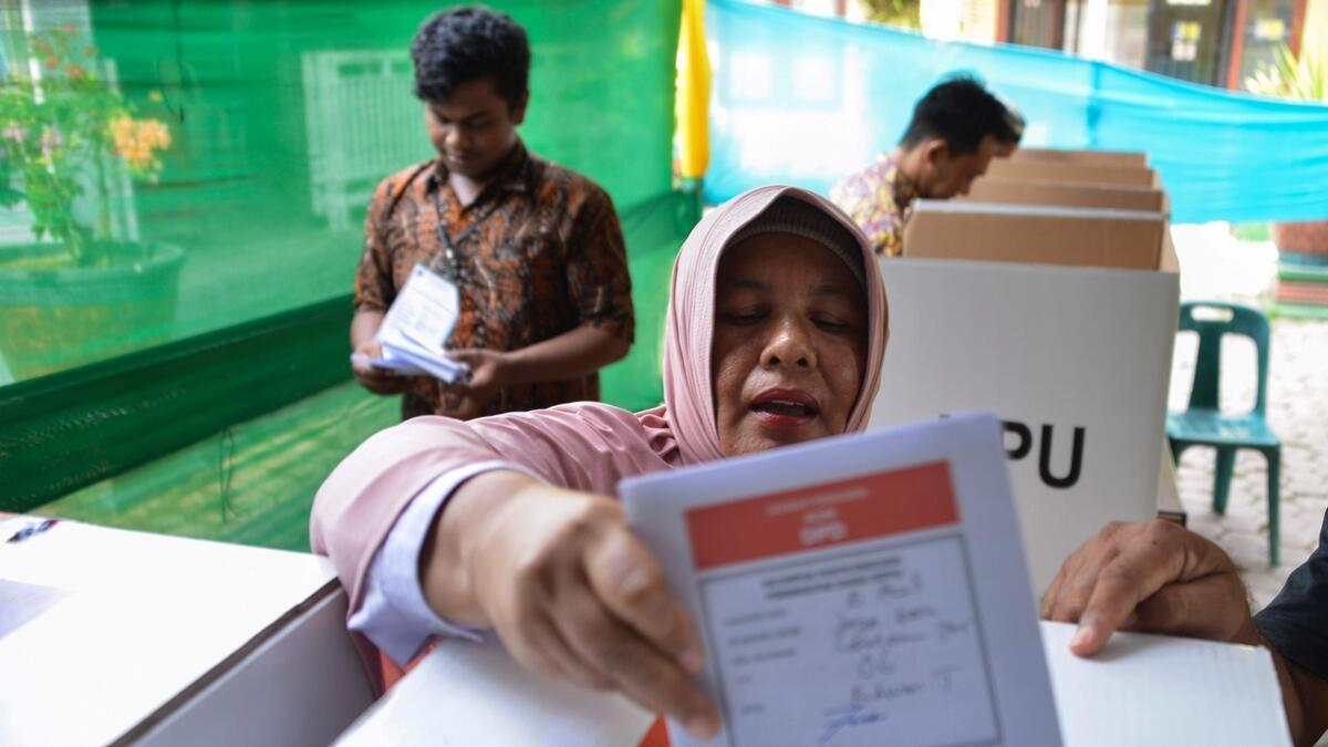 A woman casts her ballot during a revote due to logistical issues in the countrys general election in Banda Aceh.-AFP