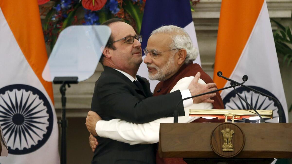 French President Francois Hollande (L) hugs India's Prime Minister Narendra Modi.
