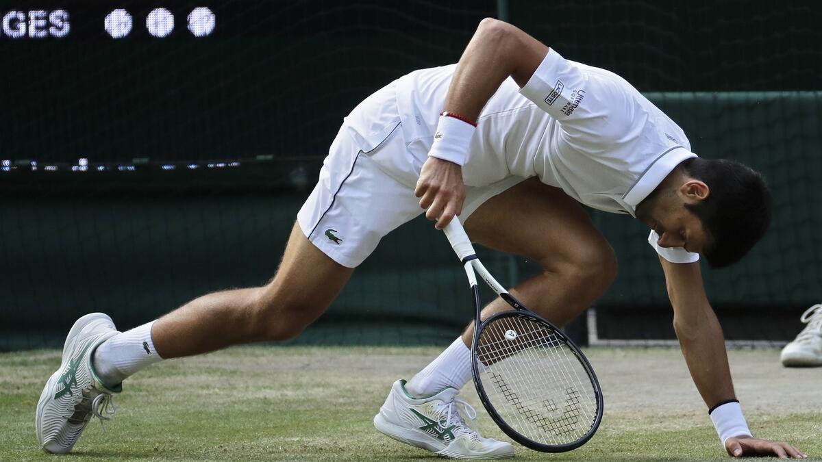 Novak Djokovic slips on the grass during the men's singles final match with Roger Federer, at the Wimbledon Tennis Championships in London. AP