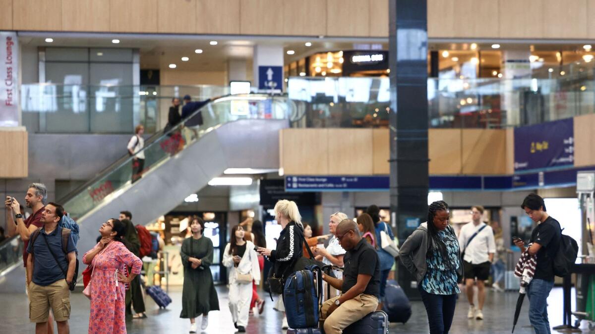 People look at departure information screens at Euston railway station as railway workers strike over pay and terms in London on Saturday. — Reuters