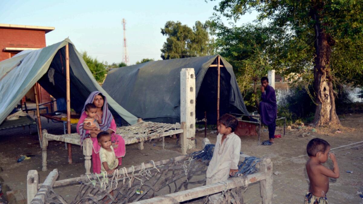 A displaced family take refuge in a camp after fleeing their flood-hit home in Rajanpur. — AP