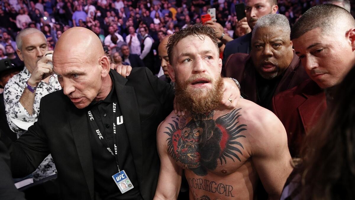 McGregor is escorted from the cage area after fighting Nurmagomedov at UFC 229. (AP)