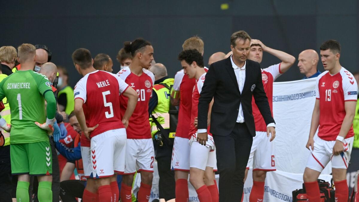 Denmark manager Kasper Hjulmand (centre) and the players react while Christian Eriksen is given medical assistance after collapsing on the pitch. (AP)