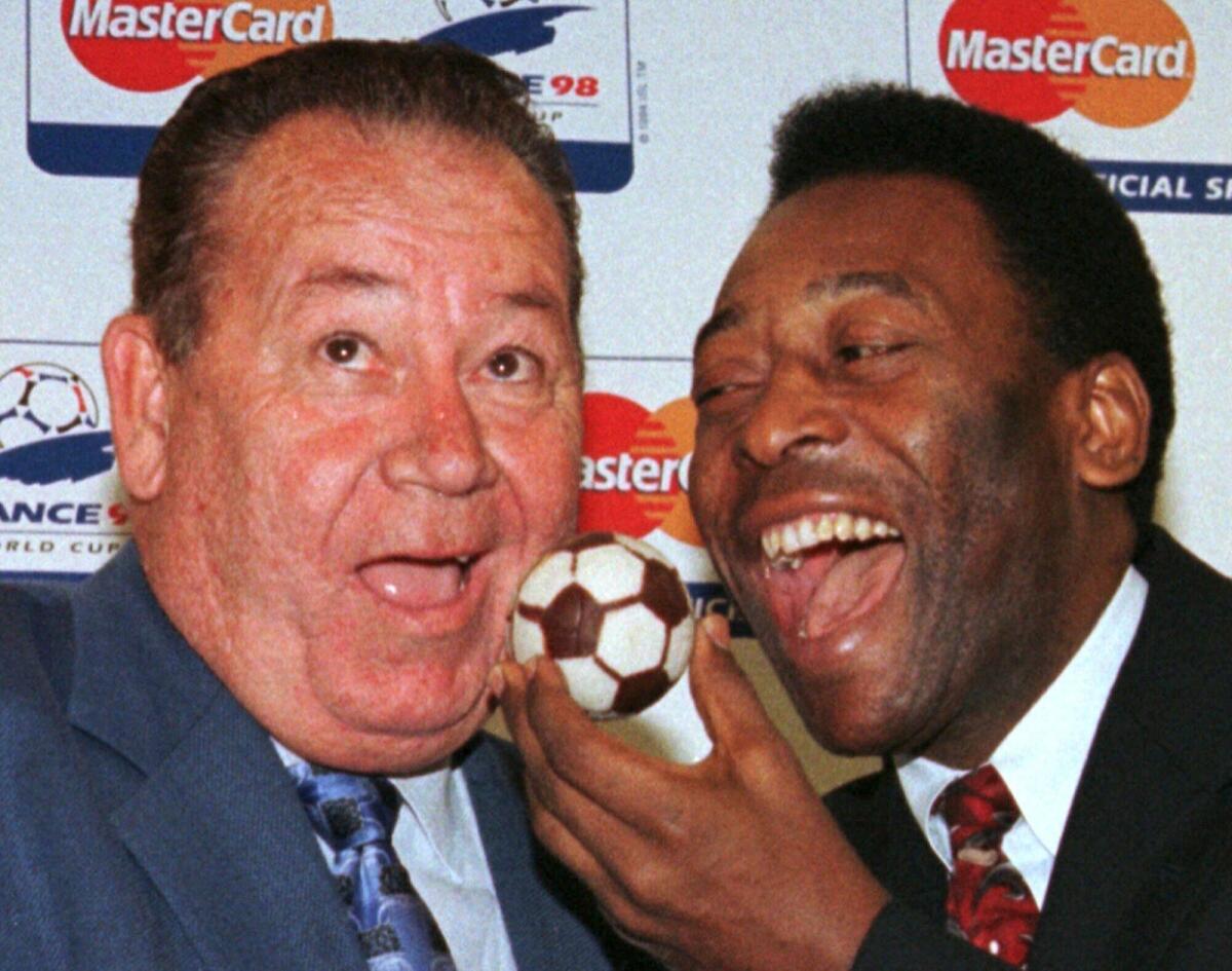Brazil's Pele (right) feeds French legend Just Fontaine with a football cake in this photo dated July 5, 1998. — AP file
