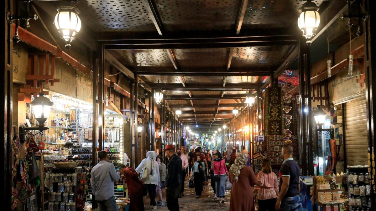 People walk through an alley of souvenir shops at a tourist market amid the coronavirus pandemic in Luxor, Egypt.