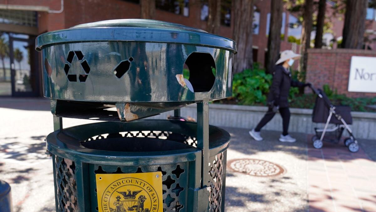 A woman walks past a Renaissance trash can that has been used for nearly 20 years in San Francisco, on July 26, 2022. — AP
