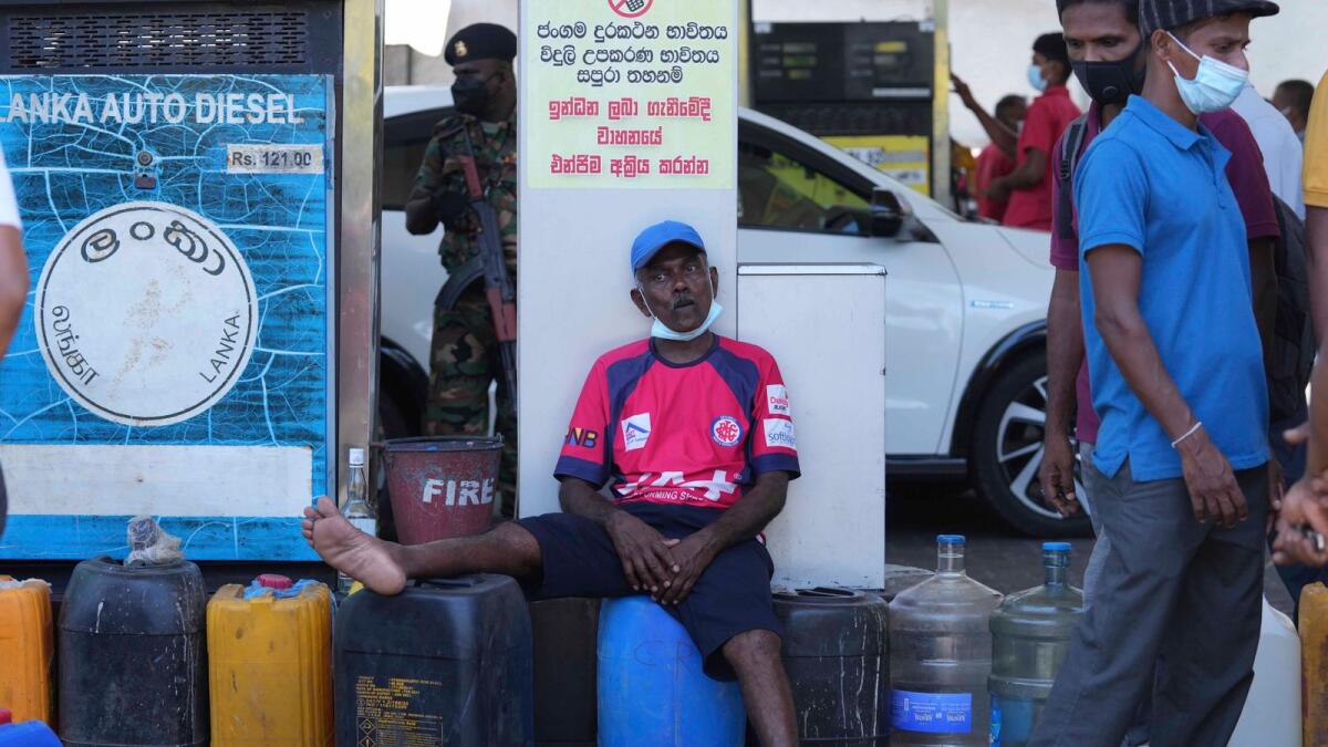A  man waits to purchase diesel at a fuel pump in Colombo. – AP