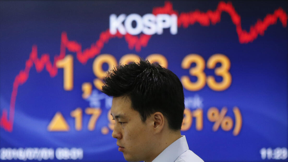 A currency trader near a screen showing the Korea Composite Stock Price Index in Seoul. South Korea’s benchmark KOSPI index has lost about 17 per cent so far this year. - AP file