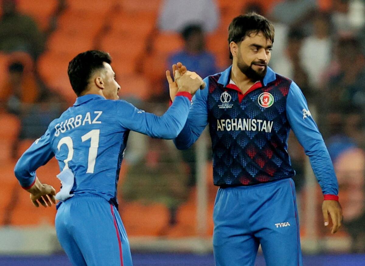 Afghanistan's Rashid Khan celebrates with teammate Rahmanullah Gurbaz after taking the wicket of South Africa's Heinrich Klaasen during the World Cup. — Reuters