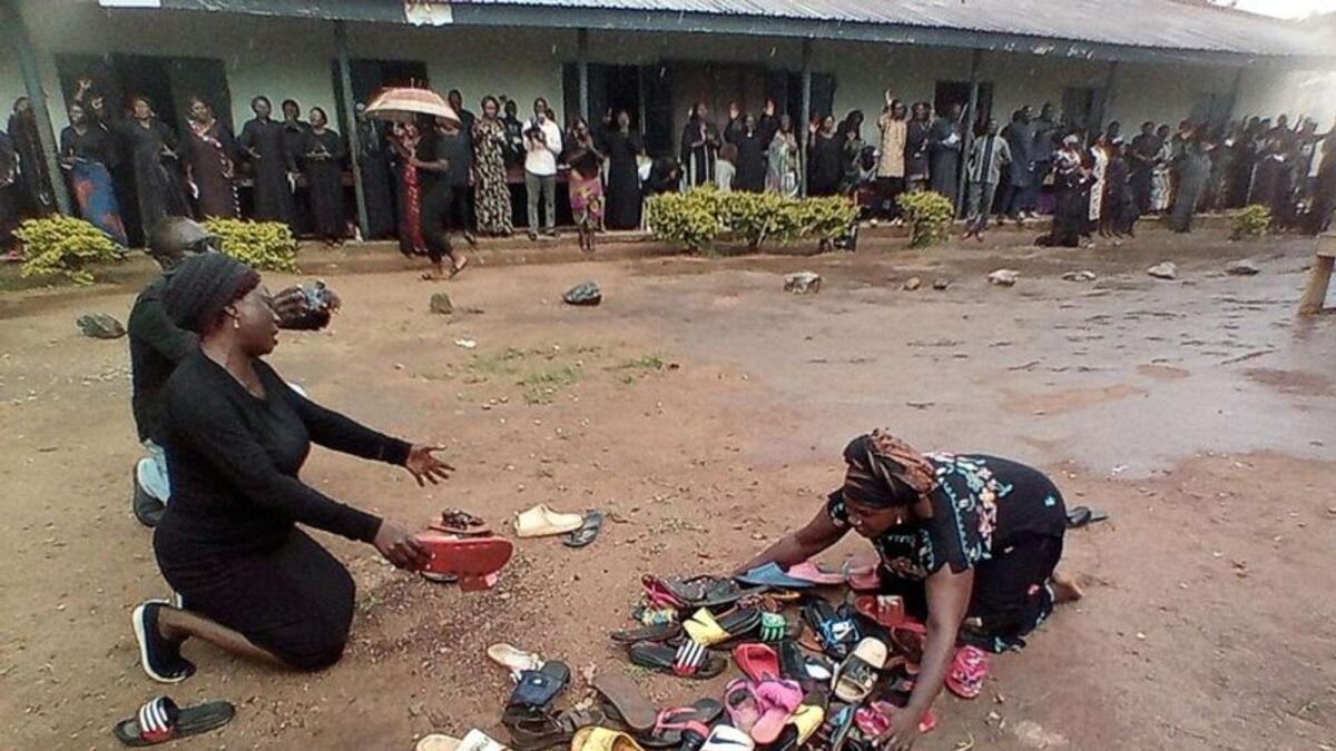 Parents of the abducted students pray for their safe return around discarded shoes left behind by the children. Photo: Reuters