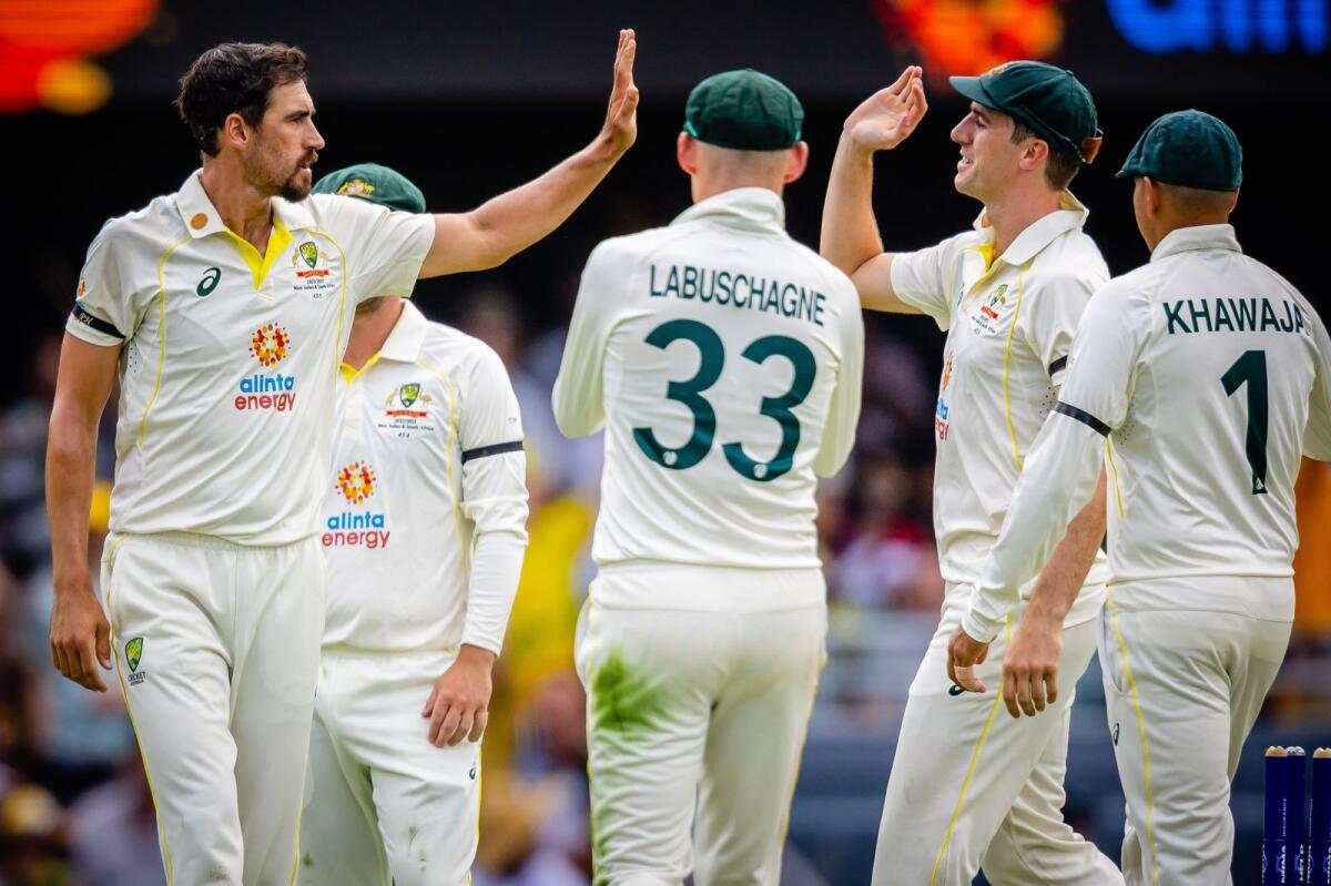 Australia's Mitchell Starc (left) celebrates with teammates after taking a wicket. — AFP