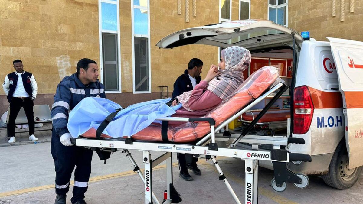 An injured Palestinian woman is transported on a gurney into an Egyptian Red Crescent ambulance vehicle after evacuation from the Gaza Strip via the Rafah border crossing into Egypt. — AFP