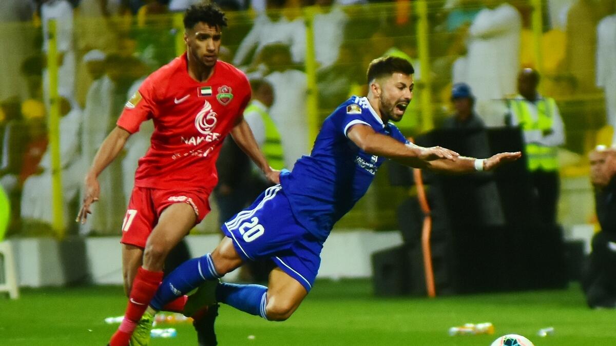Al Nasr's midfielder Antonio Jose De Carvalho (R) is marked by Shabab Al Ahli player during the match.