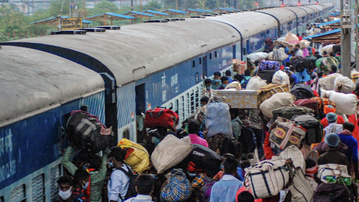 Passengers arrive at Govindpuri station to board a train to their native places, in Kanpur, India. Photo: PTI