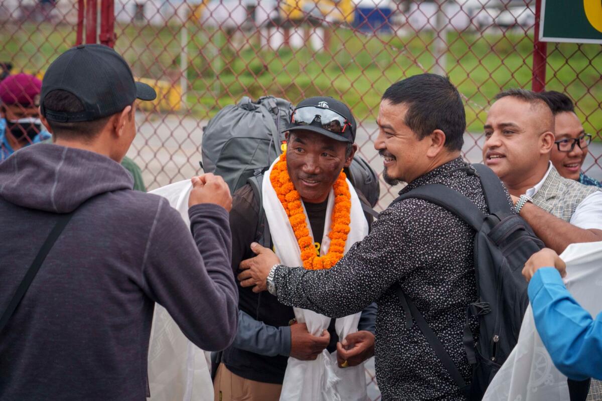 Veteran Sherpa guide Kami Rita, 53, centre, who scaled Mount Everest for the 28th time on Tuesday arrives at the airport in Kathmandu, Nepal, on May 25, 2023.  Photo: AP