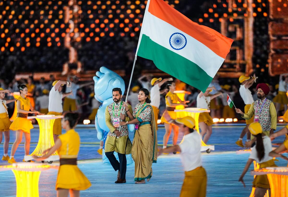 Flag-bearers Lovlina Borgohain and Harmanpreet Singh lead the Indian contingent during the opening ceremony of the 19th Asian Games. - PTI