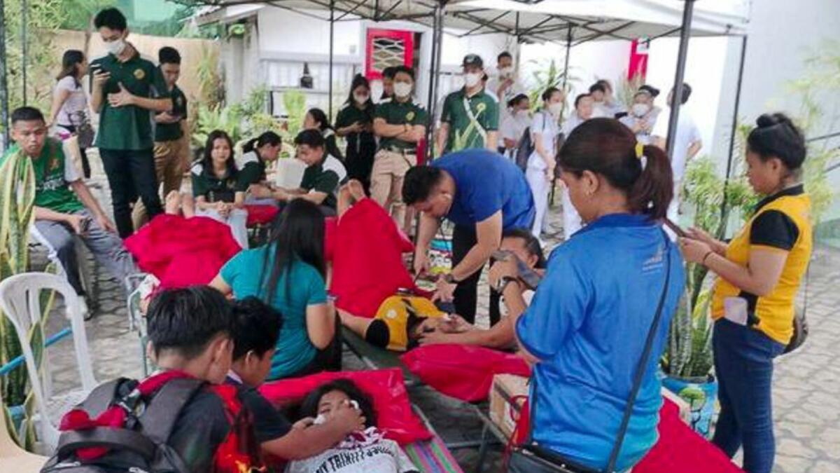 In this handout photo provided by the Philippine Red Cross, volunteers attend to people affected by an earthquake that struck General Santos City, South Cotabato, southern Philippines on Friday Nov 17. (Philippine Red Cross via AP)