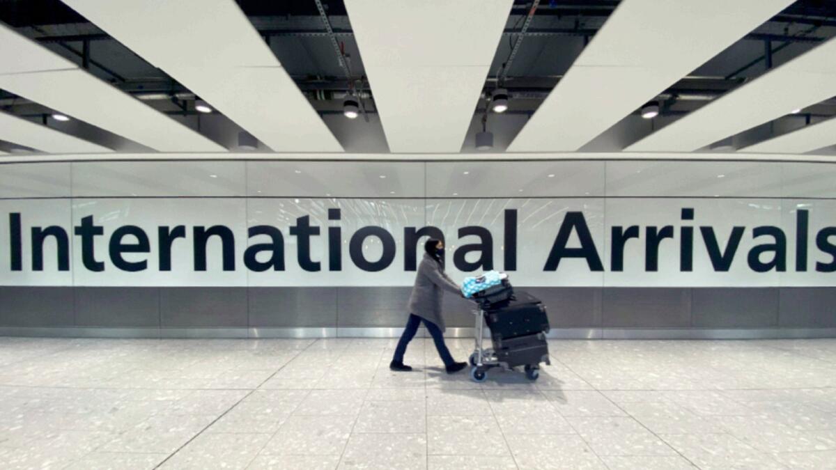 A passenger walks through International Arrivals, at London's Heathrow Airport. — AP file