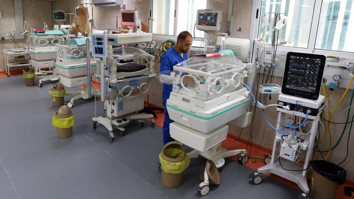 A medical worker assists a premature Palestinian baby who lies in an incubator at the maternity ward of Al Shifa Hospital. — Reuters file