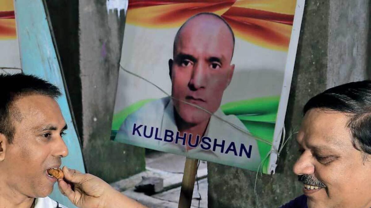 Friends of Kulbhushan Jadhav share sweets as they celebrate the verdict of International Court of Justice in Mumbai.— AP