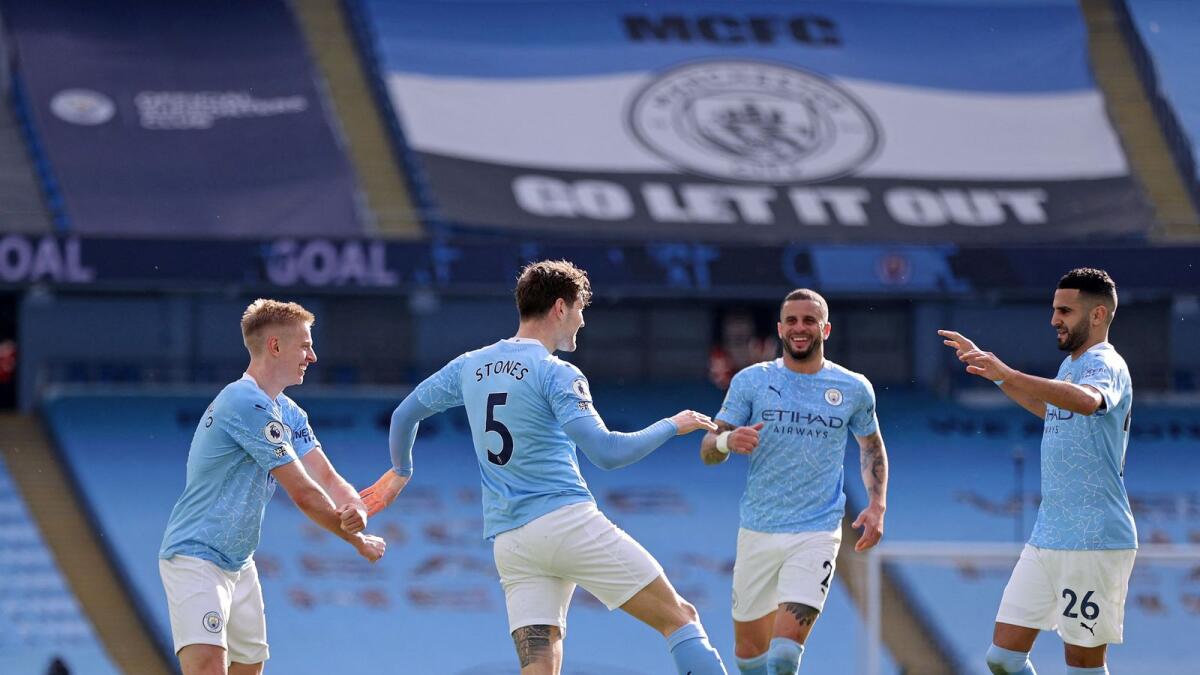 Manchester City's English defender John Stones (second left) celebrates his goal against west Ham United during the English Premier League match with his teammates. — AFP