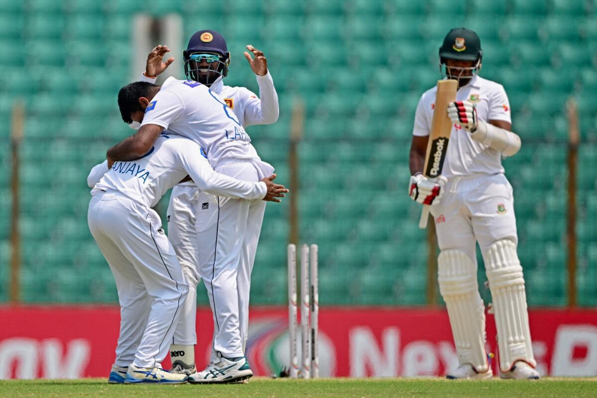Sri Lanka's players celebrate their win as Bangladesh's Khaled Ahmed (right) reacts at the end of the final day of the second  Test. — AFP