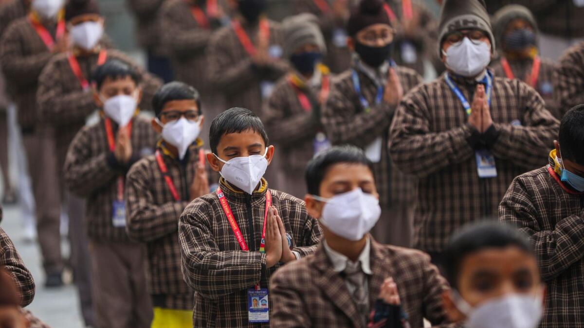 School students wear face masks during prayer in Jammu on Friday. Photo: PTI
