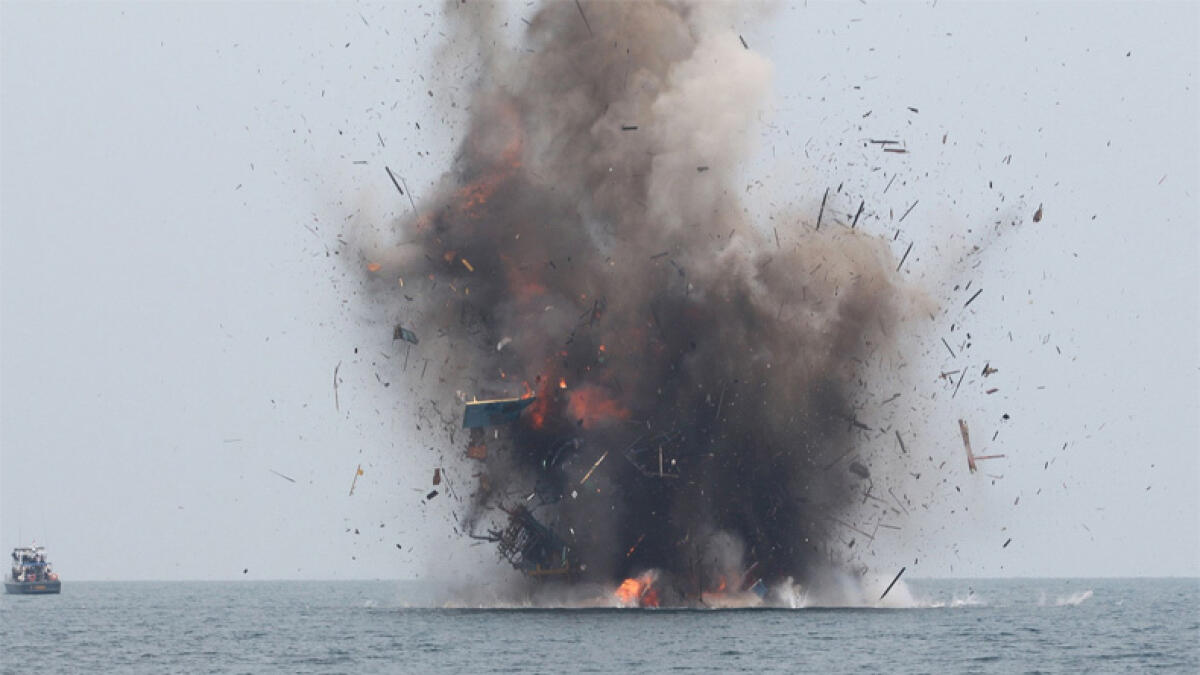 An illegal fishing boat being blown up with explosives by Indonesian authorities in Kuala Langsa, Aceh province. AP