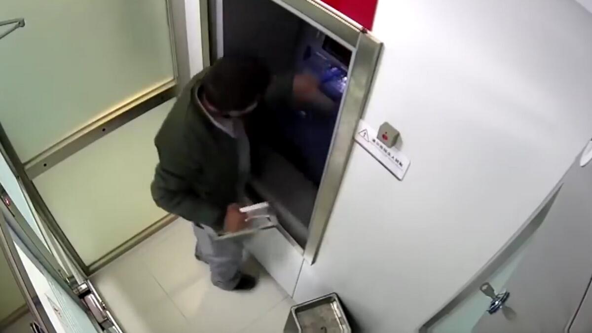 ATM robber locks door, CCTV, robber, ATM