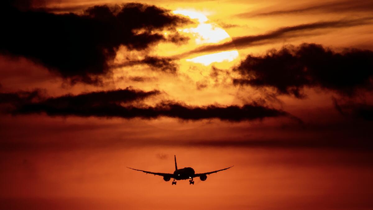 An aircraft approaches the airport in Frankfurt, Germany, as the sun rises. With more and more tourists coming back from vacation rising numbers over Covid-19 infections are expected all over Germany. Photo: AP