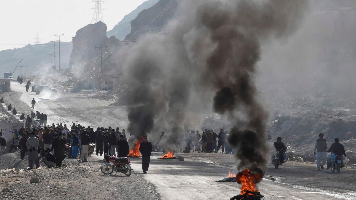 Members of Hazara community burn tyres during a protest after the killing of 11 workers of their community, in Quetta on Sunday.