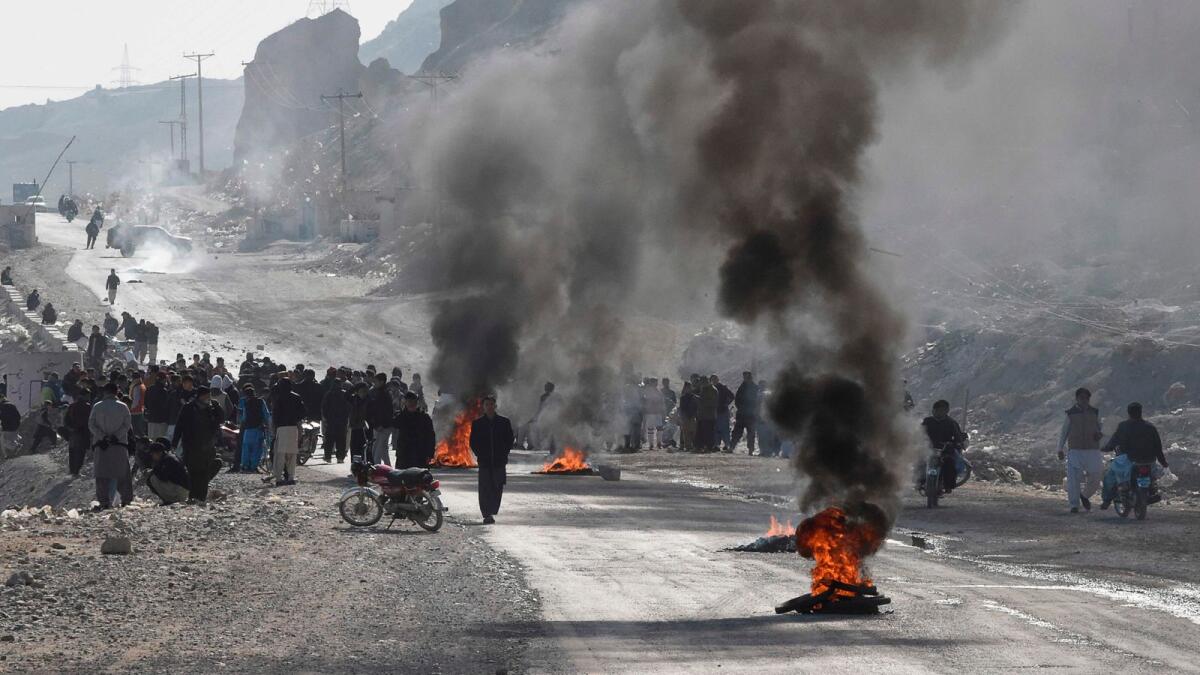 Members of Hazara community burn tyres during a protest after the killing of 11 workers of their community, in Quetta on Sunday.