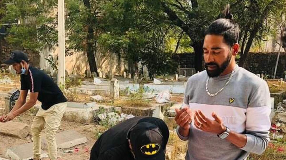 Mohammed Siraj at his father's grave after his arrival from Australia. — Twitter