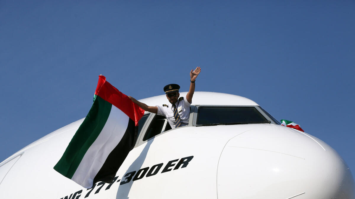 The Emirati pilot raises the UAE National Flag upon landing in Bologna to mark the new route and UAE Flag Day.