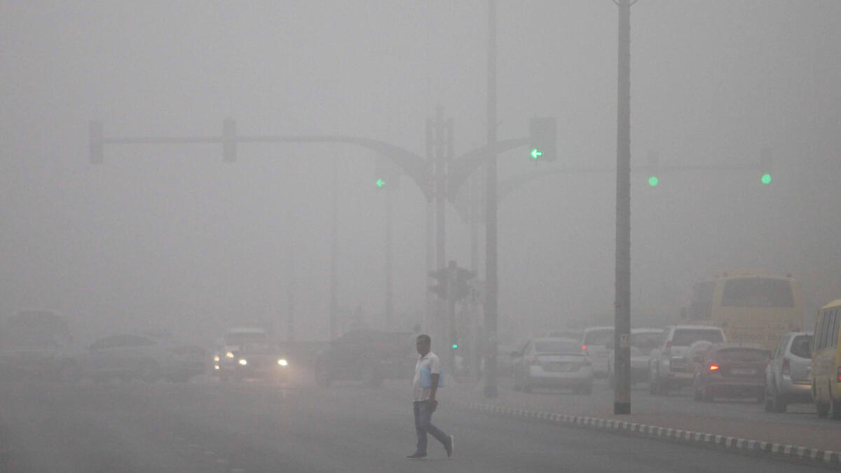A man crossing the road during a foggy morning at the Al Mahatta area in Sharjah.– Photo by M. Sajjad/Khaleej Times