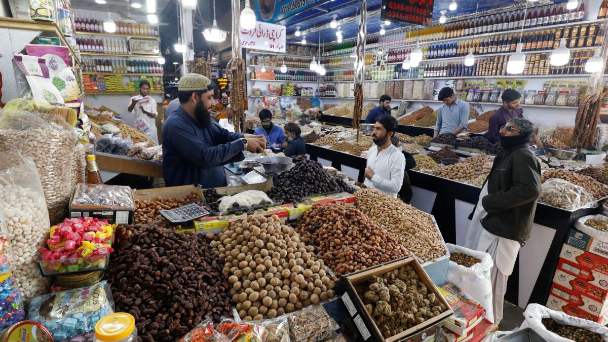 People buy dry fruits at a market in Karachi on Wednesday. - Reuters