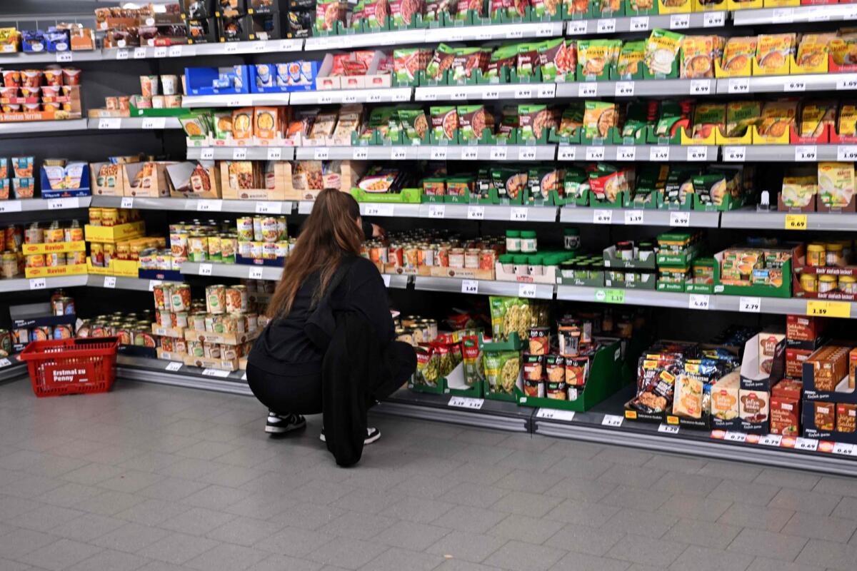 A woman picks items from a shelf at a store of the Penny supermarket chain in Berlin, Germany, on August 1, 2023. Photo: AFP