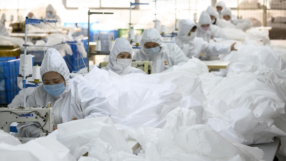 Workers making hazardous material suits to be used in the Covid-19 coronavirus outbreak at a factory in Wenzhou. A sub-index of Chinese manufacturing production nosedived to 27.8 in February from January's 51.3.