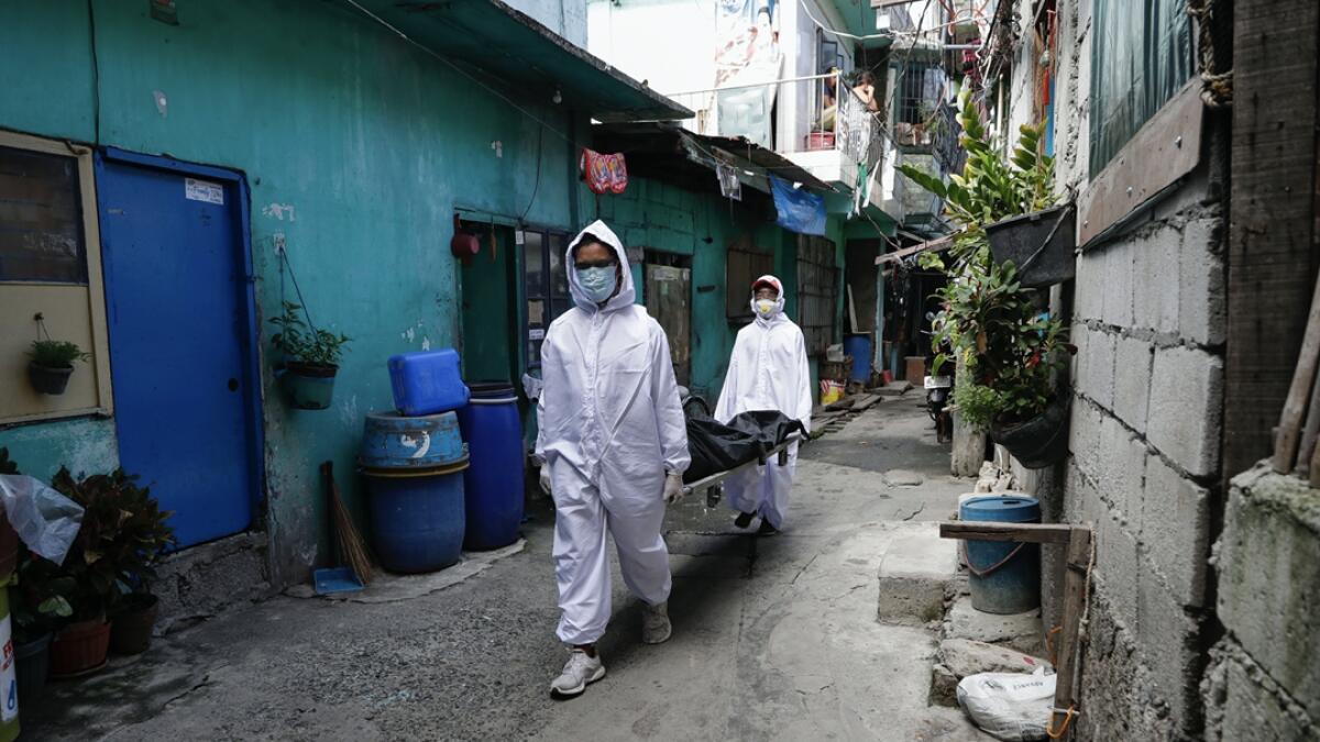 Funeral home workers in protective suits carry a body during the start of a lockdown due to a rise in Covid cases in the city of Navotas, Manila, Philippines. Photo: AP